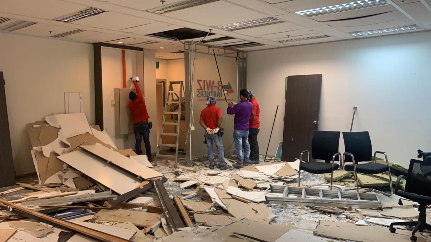 Our team dismantling office partitions and ceiling boards at a Telok Ayer Street office