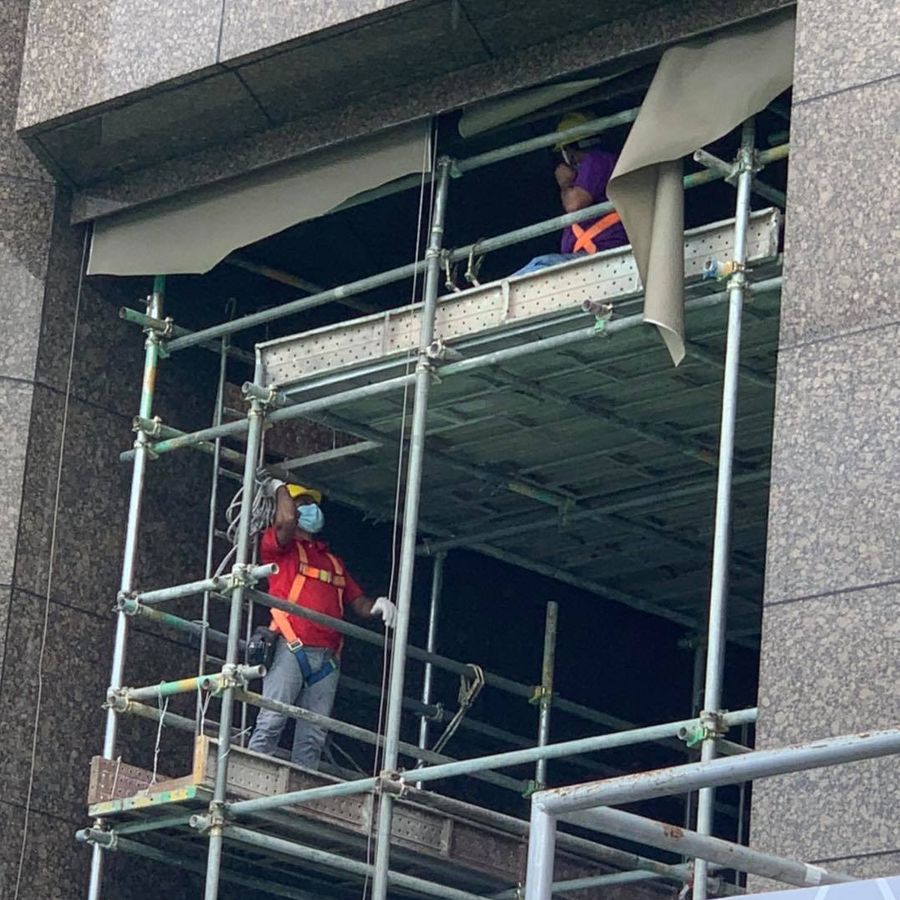 Workers on scaffolding removing a facade installation at 6 Battery Road